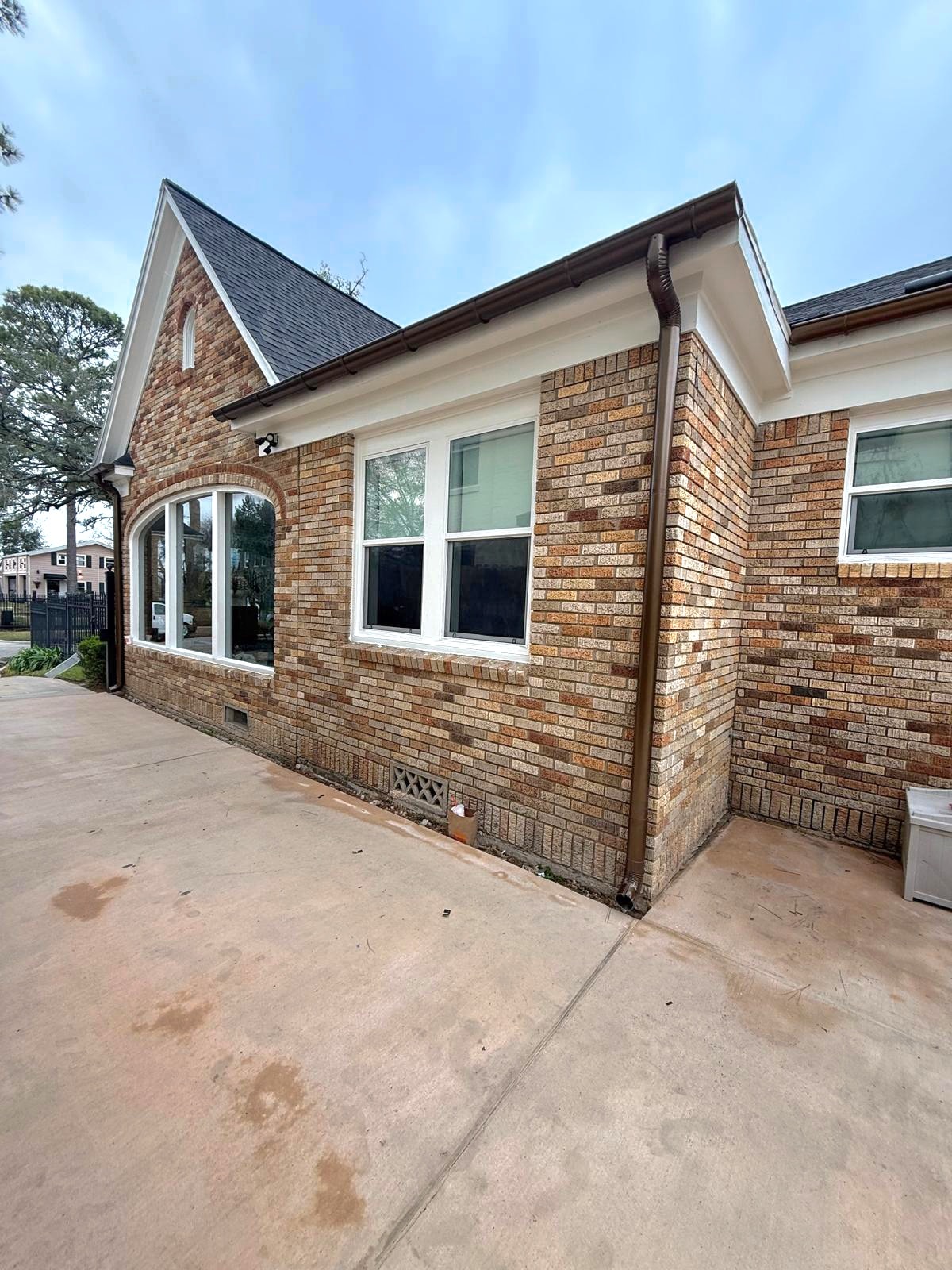 Brown downspout and seamless gutter on brick home — Houston TX