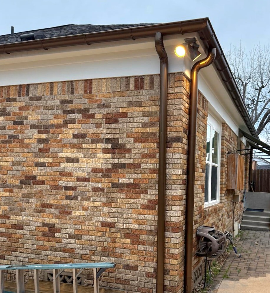 Brown seamless gutter corner detail on brick home — Houston TX