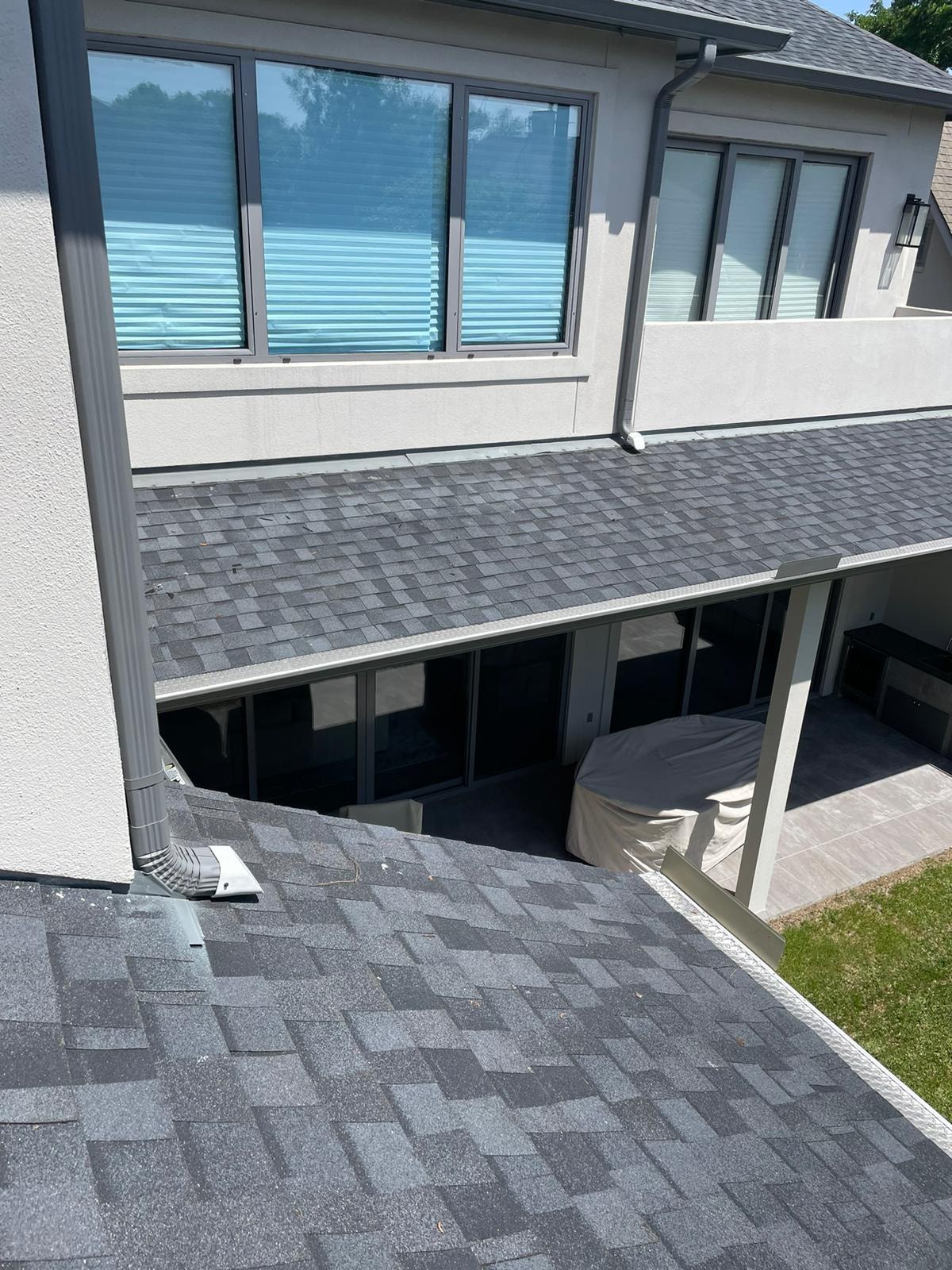 Aerial view of seamless gutter installation on covered patio home — Houston TX