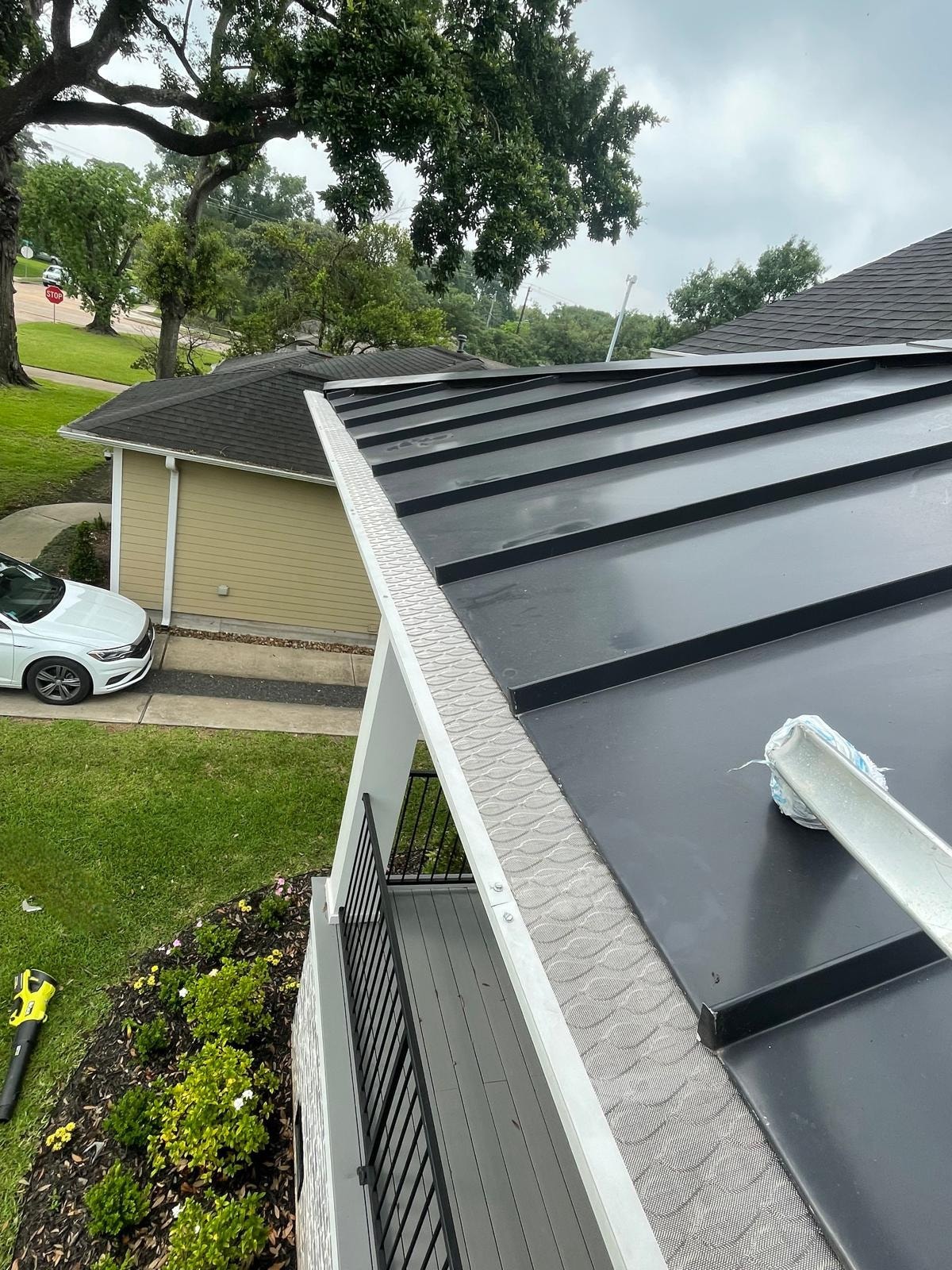 FloMaster Pro gutter guard installed along roofline with mature trees — Houston TX