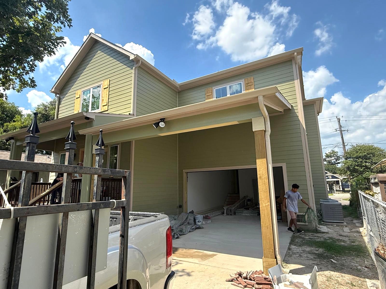 Gutter installation on sage green home during construction — Houston TX