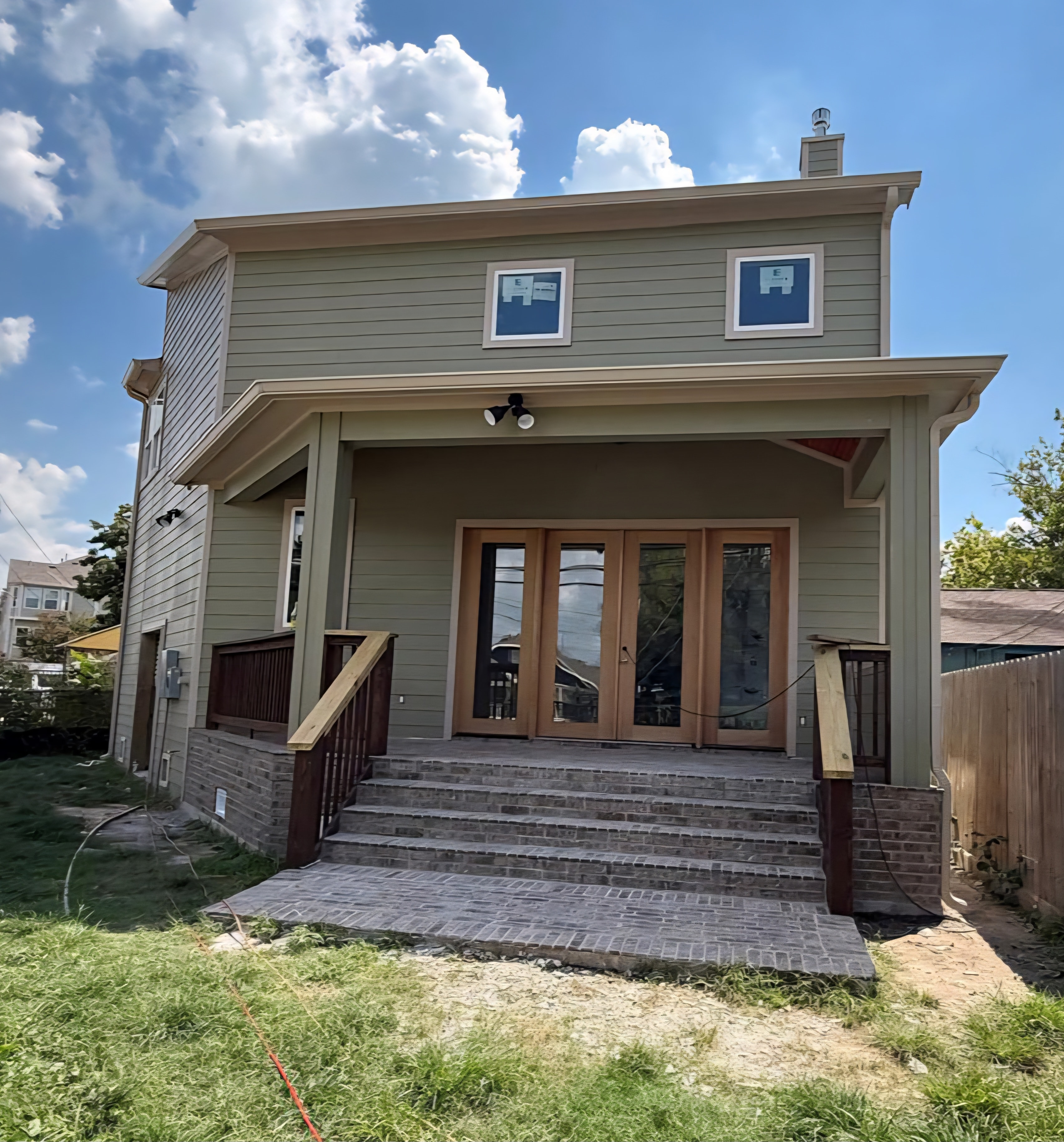 Gutter installation on sage green new construction home — Houston TX