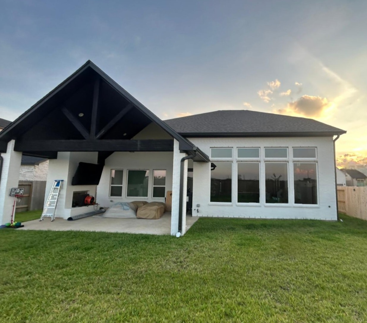 Gutter installation on white home with covered patio at sunset — Houston TX